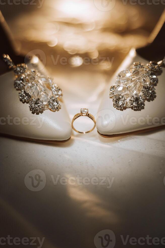 detalles de el novia. belleza es en el detalles. tacones altos nupcial zapatos. oro Boda anillo con un diamante. perfumes pendientes Boda en detalles. foto