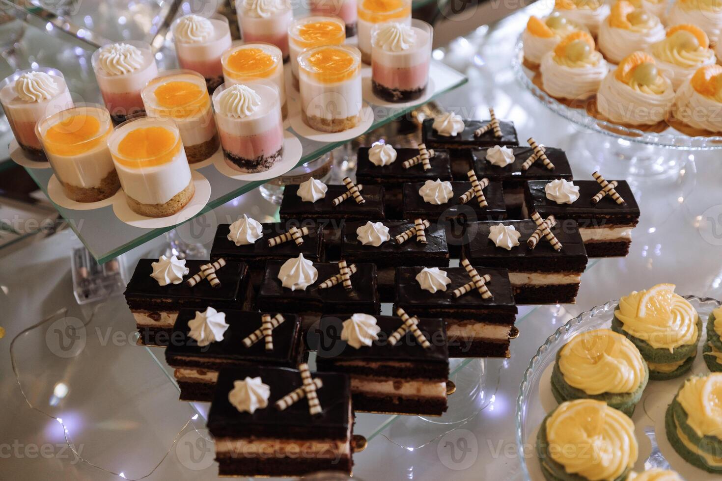 A delicious wedding. Cupcakes, cakes. Candy bar for a banquet. Celebration concept. Fashionable desserts. Table with sweets, candies. Fruits photo