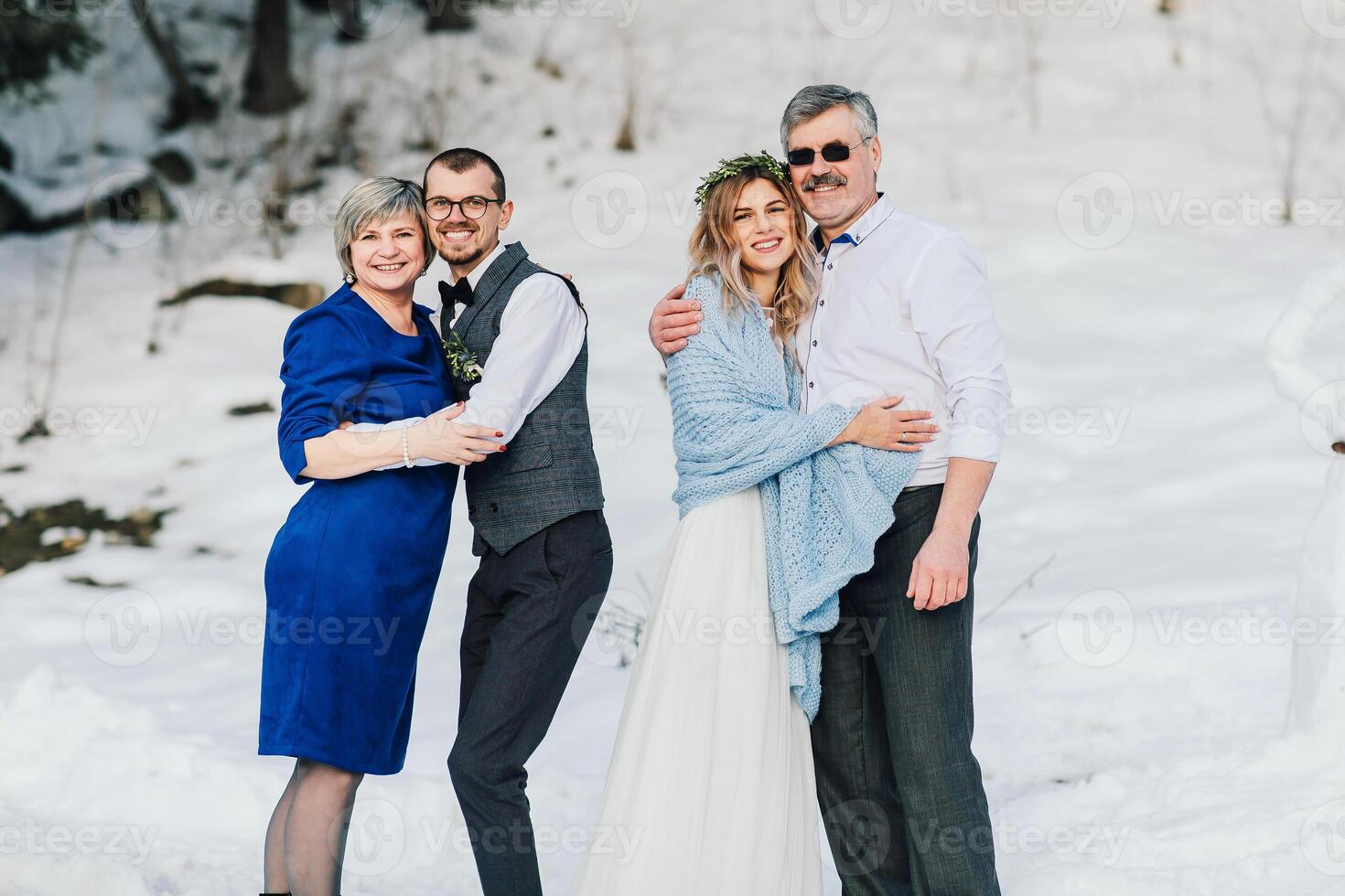 Weddings, couples and family celebrating marriage for commitment, trust or relationship support. Portrait of married bride and groom with happy parents. Wedding in winter photo