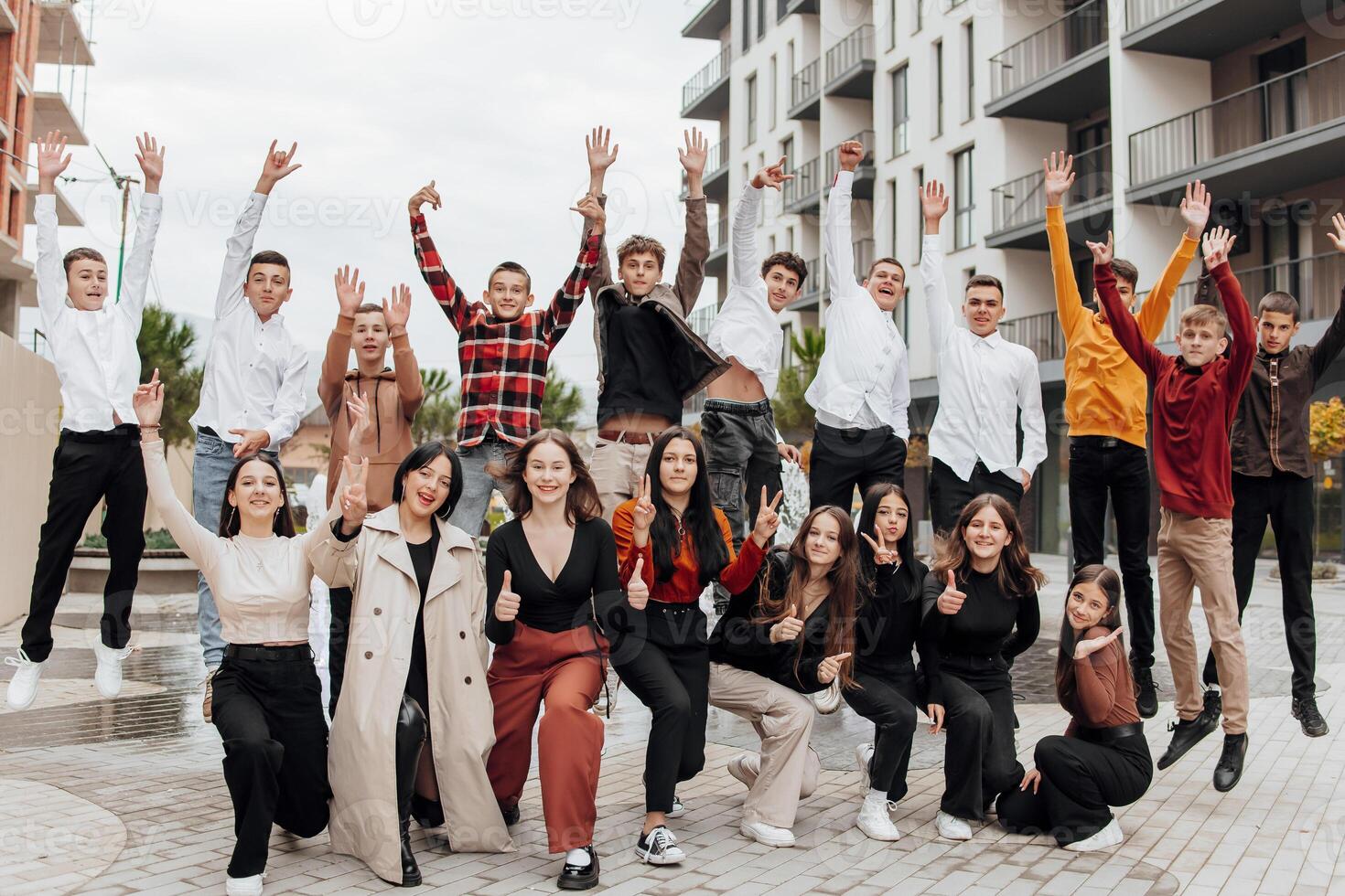 friendship, movement, action, freedom and people concept - group of happy teenagers or school friends posing and having fun outdoors on background of beautiful place or college. photo