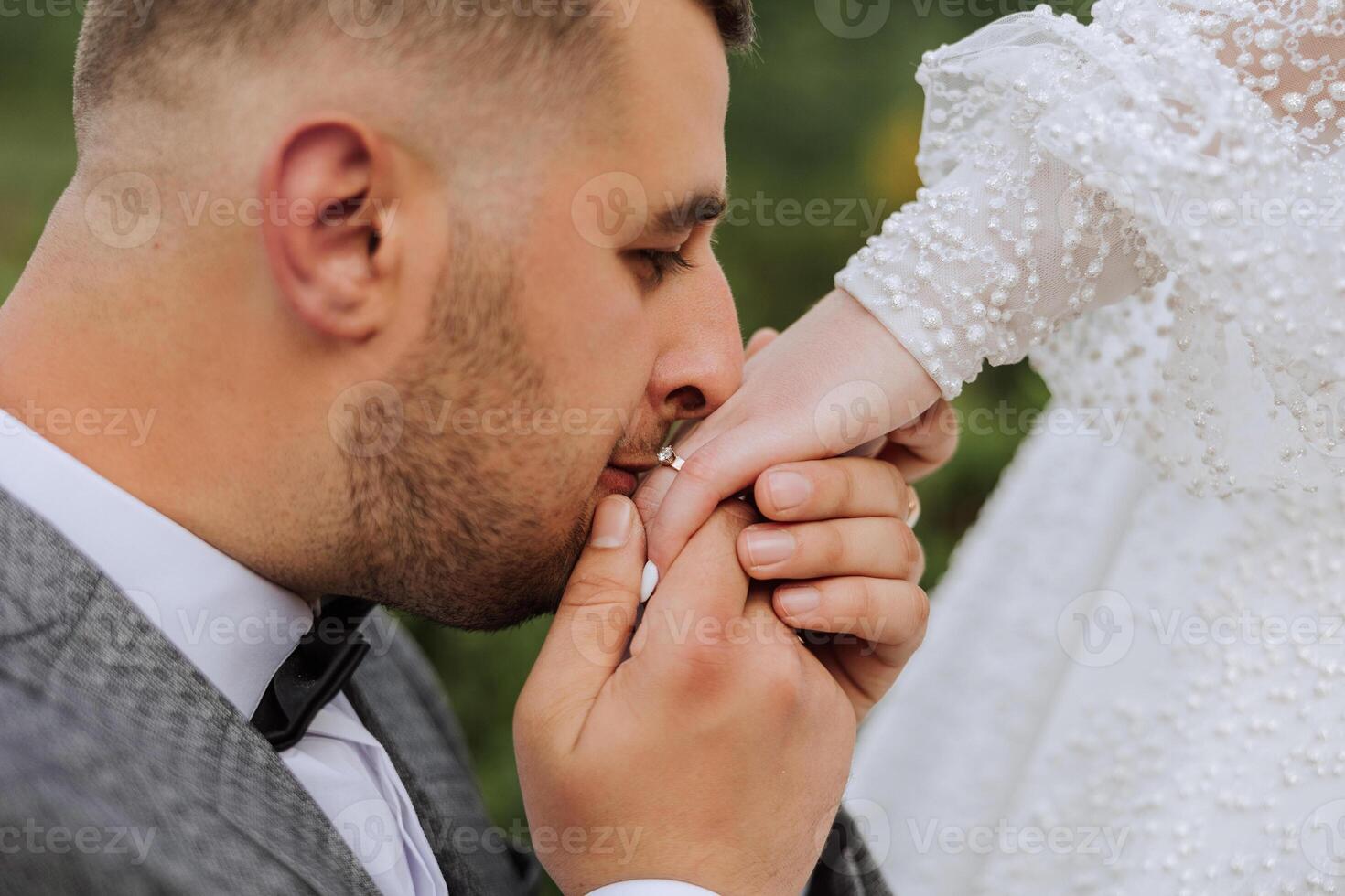 She told him yes. A young man kisses his wife's hand with a gold ring, proposing marriage. Engagement of a young couple in love. Concept of love and unity. photo