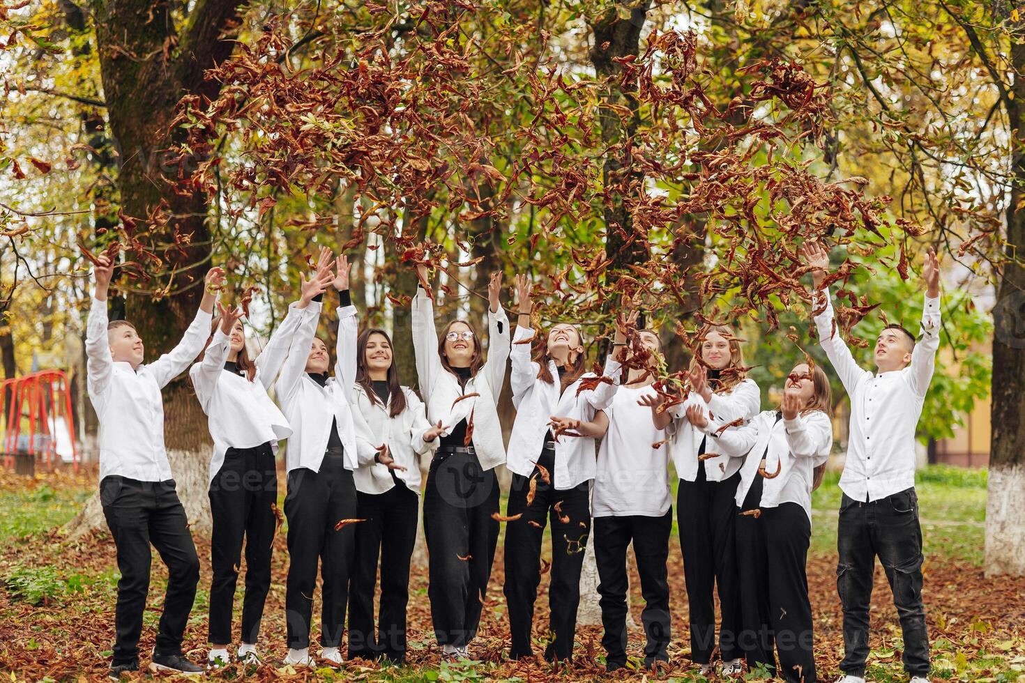 friendship, movement, action, freedom and people concept - group of happy teenagers or school friends posing and having fun outdoors against nature or forest background. photo