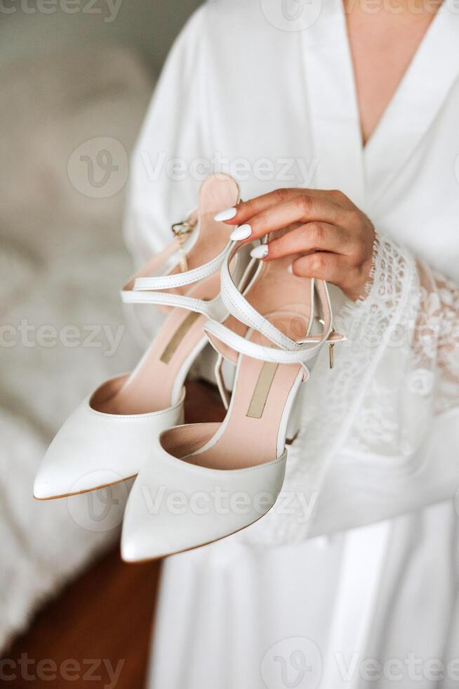 detalles de el novia. belleza es en el detalles. tacones altos nupcial zapatos. oro Boda anillo con un diamante. perfumes pendientes Boda en detalles. foto