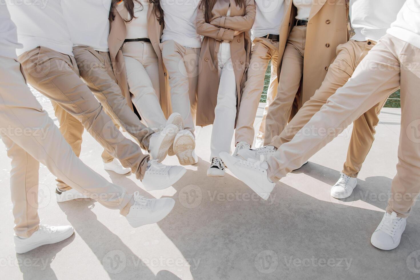 Friendship, movement, action, freedom and people concept - group of happy teenagers or school friends posing and having fun outdoors. Cropped photo of people who raised their legs.