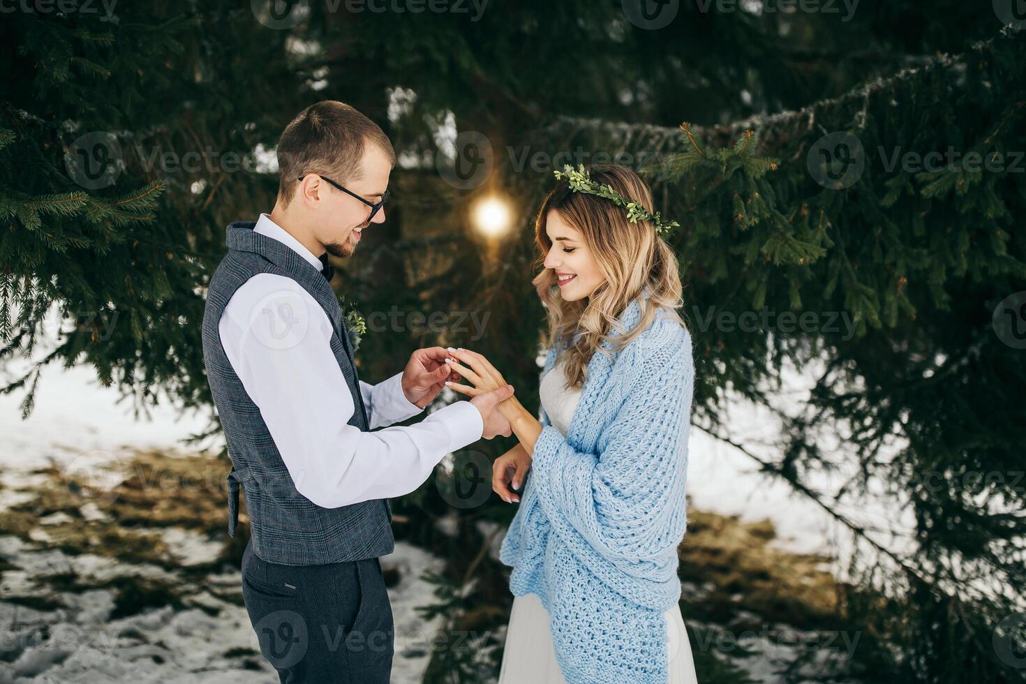 Newlyweds at the wedding ceremony. The groom puts on the bride's wedding ring. High quality photo. Winter wedding. photo