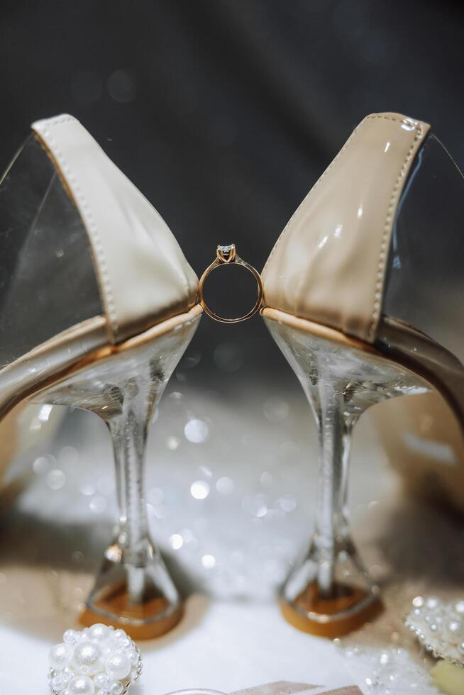 detalles de el novia. belleza es en el detalles. tacones altos nupcial zapatos. oro Boda anillo con un diamante. perfumes pendientes Boda en detalles. foto