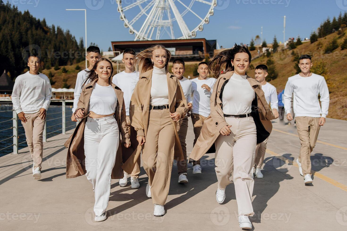 friendship, movement, action, freedom and people concept - group of three happy teenagers or school friends running forward and having fun outdoors on the background of a beautiful place. photo