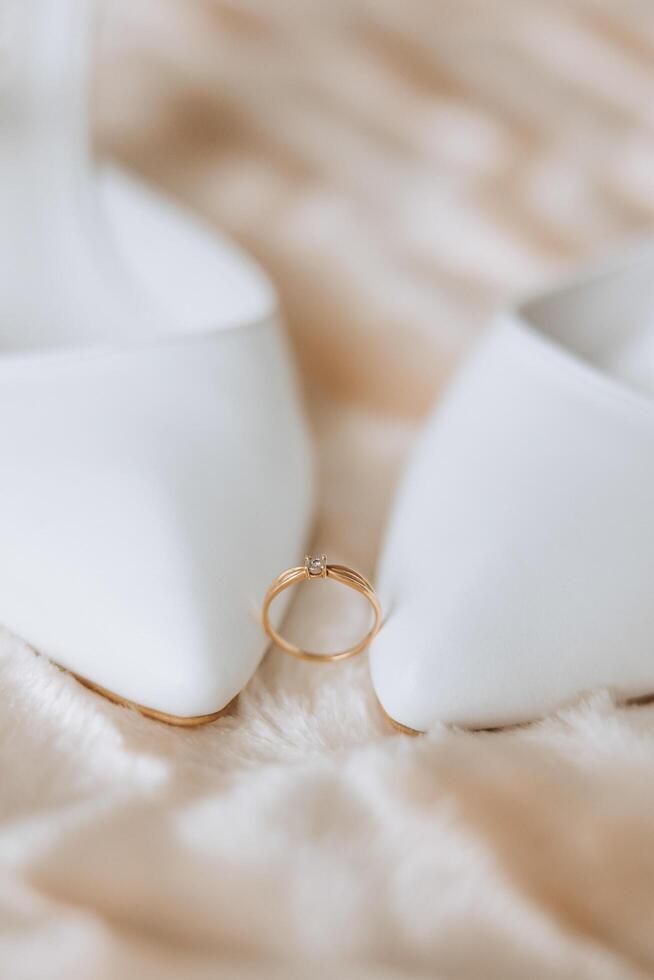 detalles de el novia. belleza es en el detalles. tacones altos nupcial zapatos. oro Boda anillo con un diamante. perfumes pendientes Boda en detalles. foto