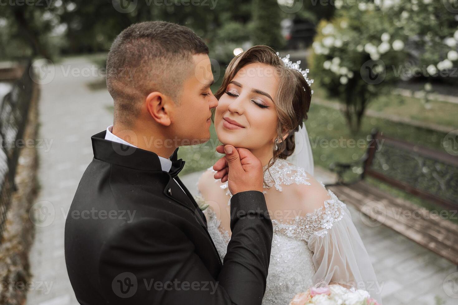 Wedding. Love and couple in garden for wedding. Celebrating the ceremony and commitment. Save the date. Trust. The groom embraces the bride. Tender kisses. Couple in love. Wedding portrait photo