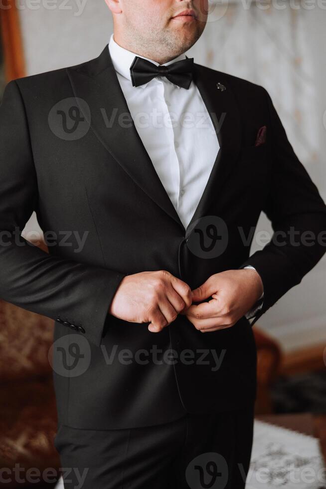 el hombre sujeta el botones en su chaqueta. el novio es preparando para el Boda ceremonia. detallado de cerca foto de manos