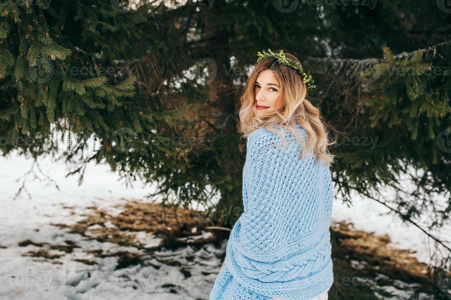 portrait of a cute bride wrapped in a blue blanket against the background of a winter landscape. Winter wedding. photo