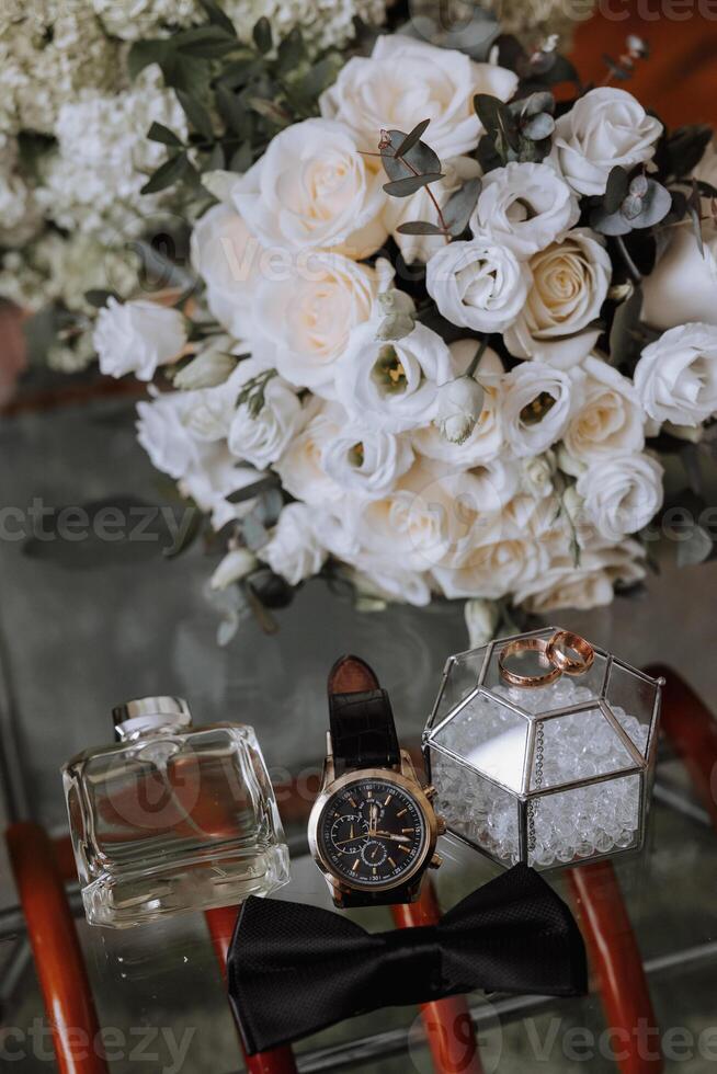 Men's accessories, groom details. Beauty is in the details. Preparation for the Wedding. Leather shoes. Gold wedding rings. Bow tie. Wedding bouquet of flowers. photo