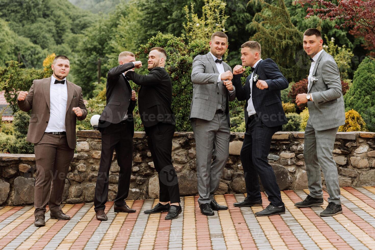 Cheerful, young, energetic witnesses of the groom next to the groom. Friends congratulate the groom. Groom and his funny friends having fun on the wedding day of the newlyweds. photo