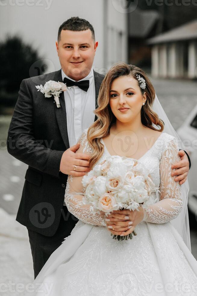 Boda Pareja en amor. un hermosa novia y un elegante novio tiernamente abrazo y disfrutar el día. un elegante Pareja de recién casados. concepto de matrimonio foto