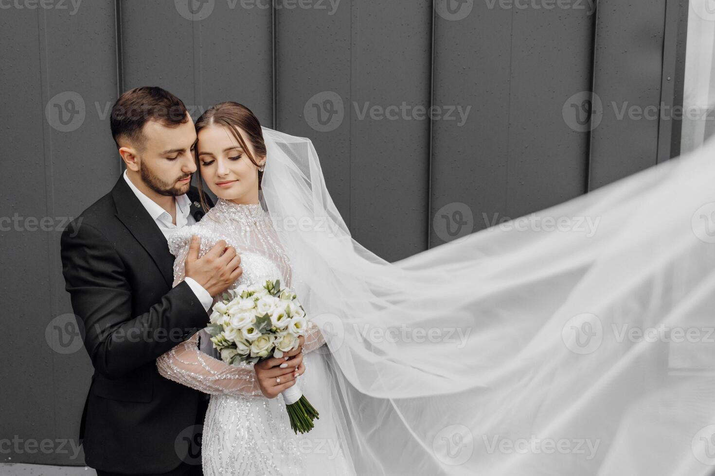 el hermosa novia suavemente abrazos el acicalar, quien abrazos su por el espalda. Boda concepto. el belleza y sensibilidad de un hombre y un mujer foto