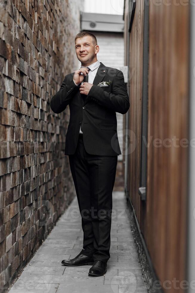 un hombre poses en un traje cerca un Roca pared. negocio estilo. novio en un traje. foto