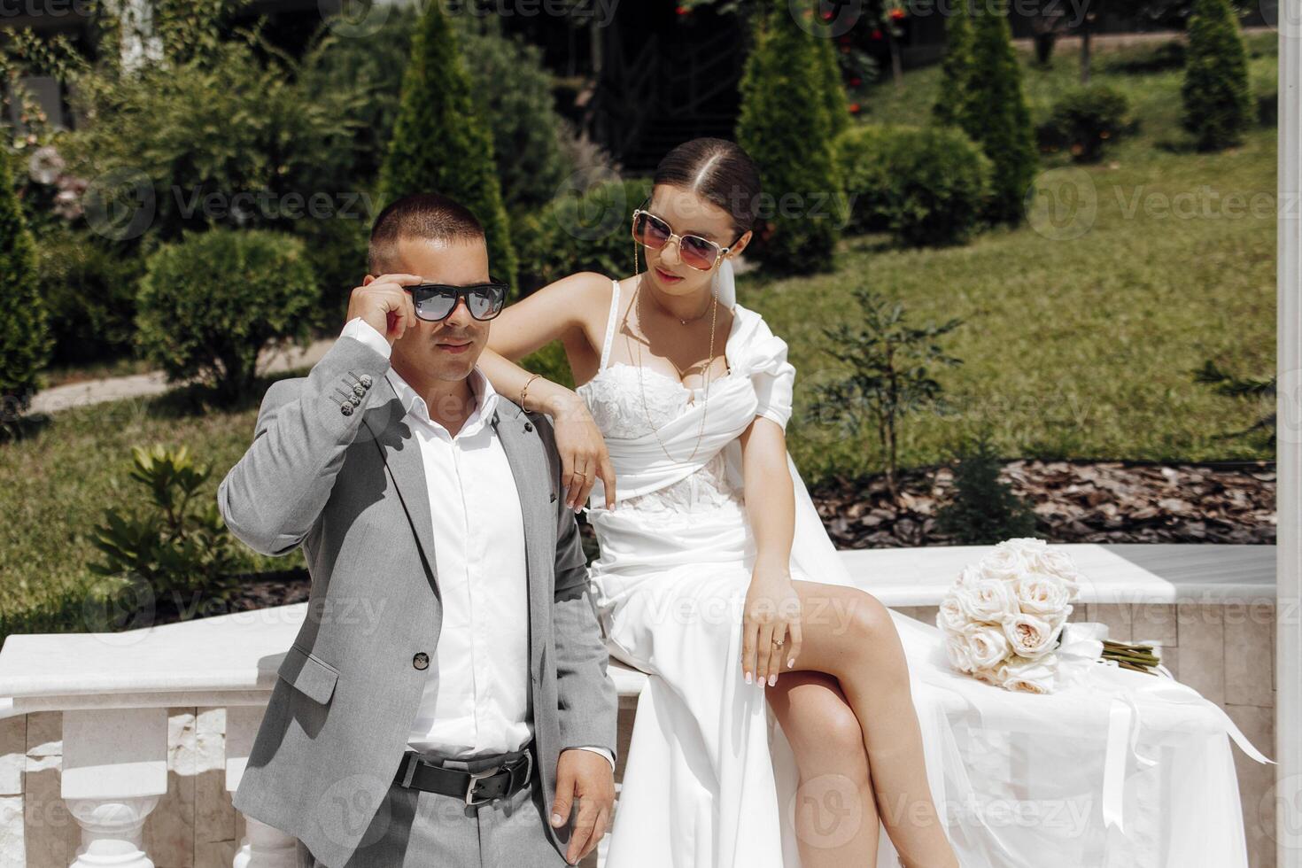 frio novia y novio teniendo divertido y vistiendo Gafas de sol al aire libre en soleado clima foto