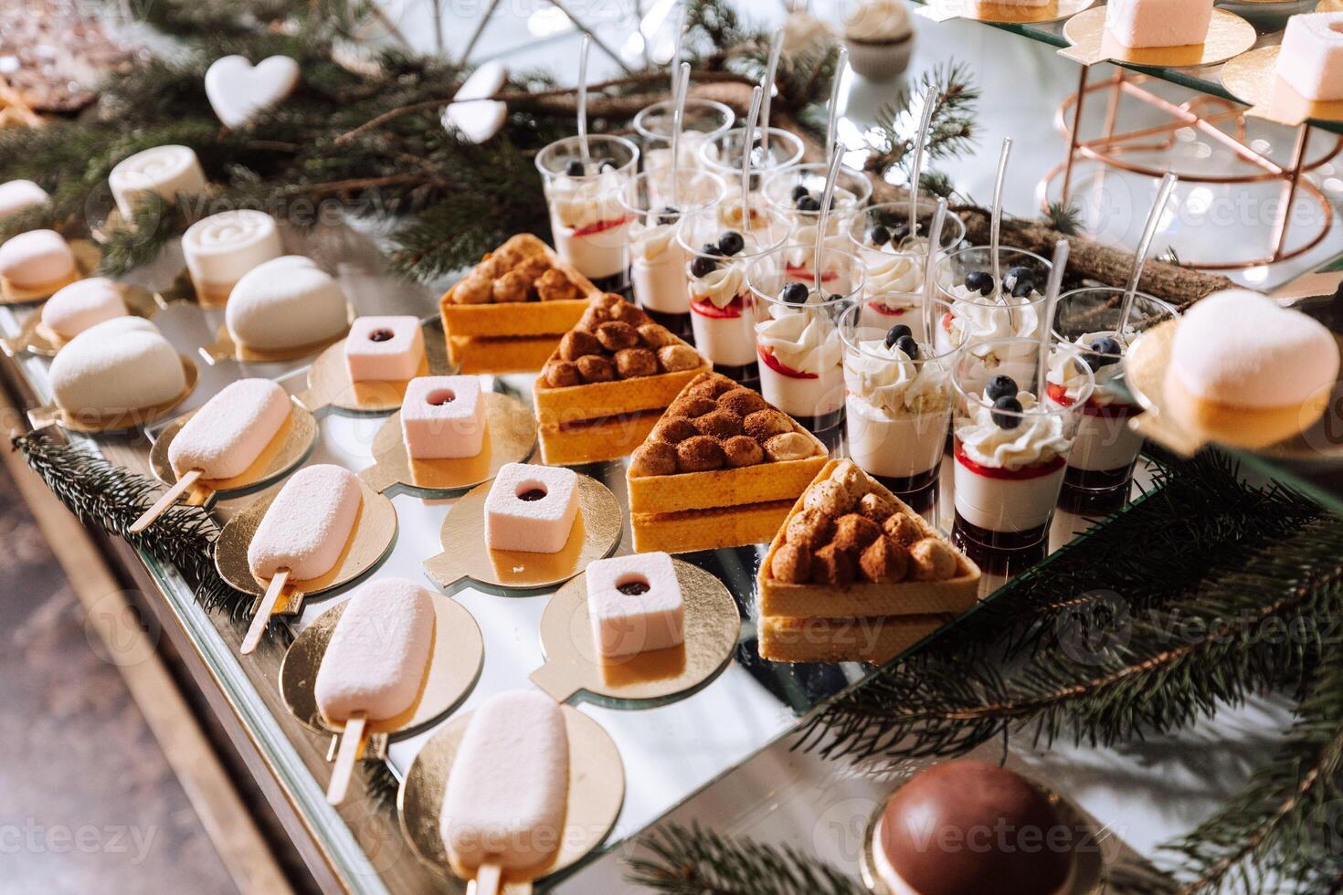 A delicious wedding. White cake decorated with flowers. Candy bar for a banquet. Celebration concept. Fashionable desserts. Table with sweets, candies. Fruits photo