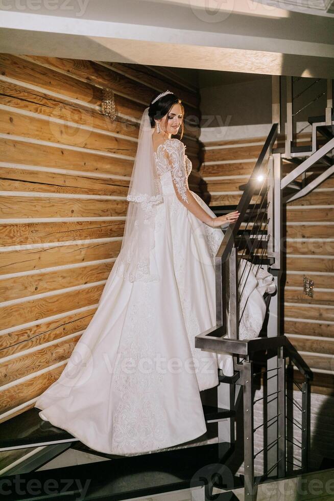 Elegant brunette bride posing in a white dress. Portrait of the bride, wedding makeup and hairstyle, wedding fashion. Beautiful bride in a veil. photo