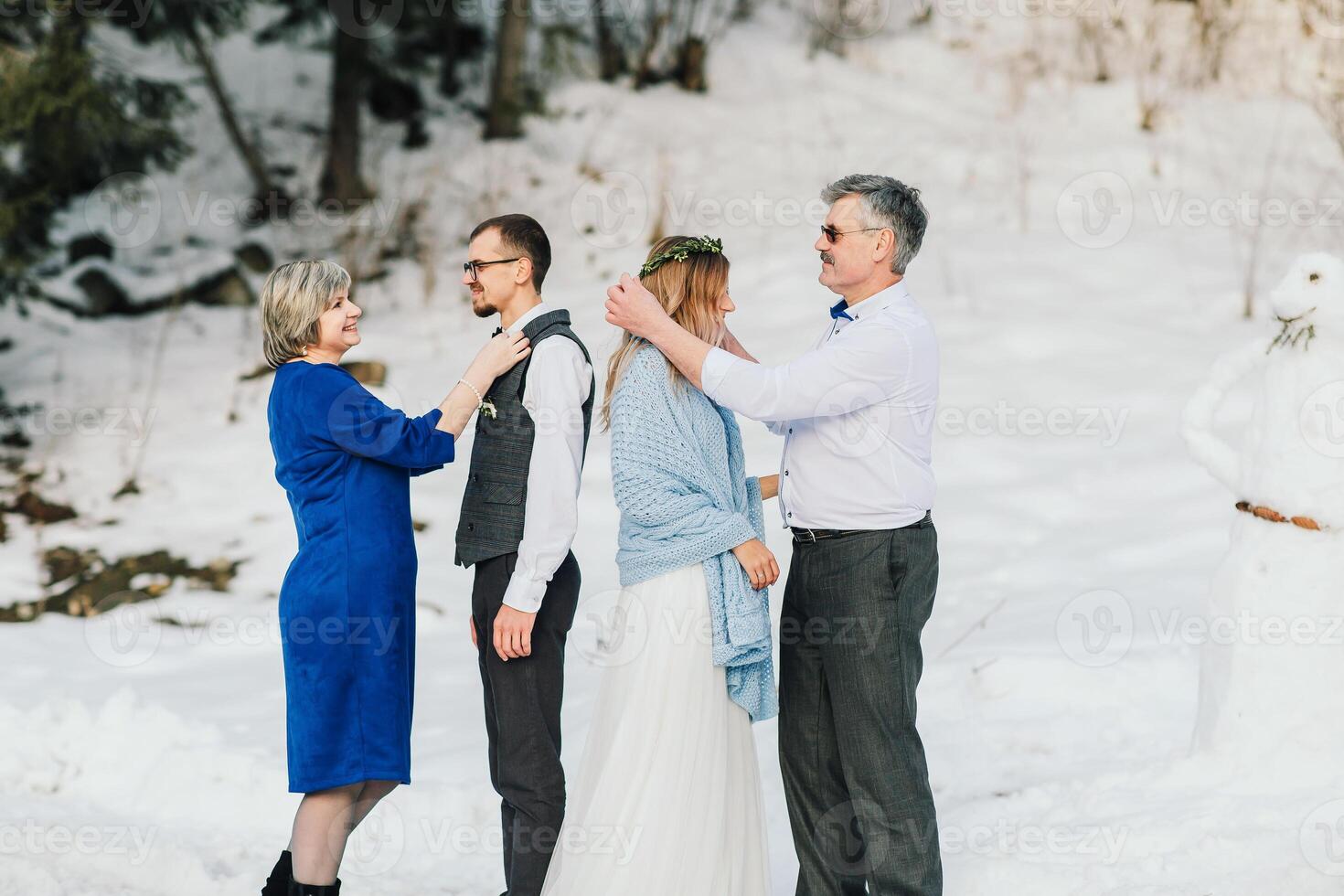 bodas, parejas y familia celebrando matrimonio para compromiso, confiar o relación apoyo. retrato de casado novia y novio con contento padres. Boda en invierno foto