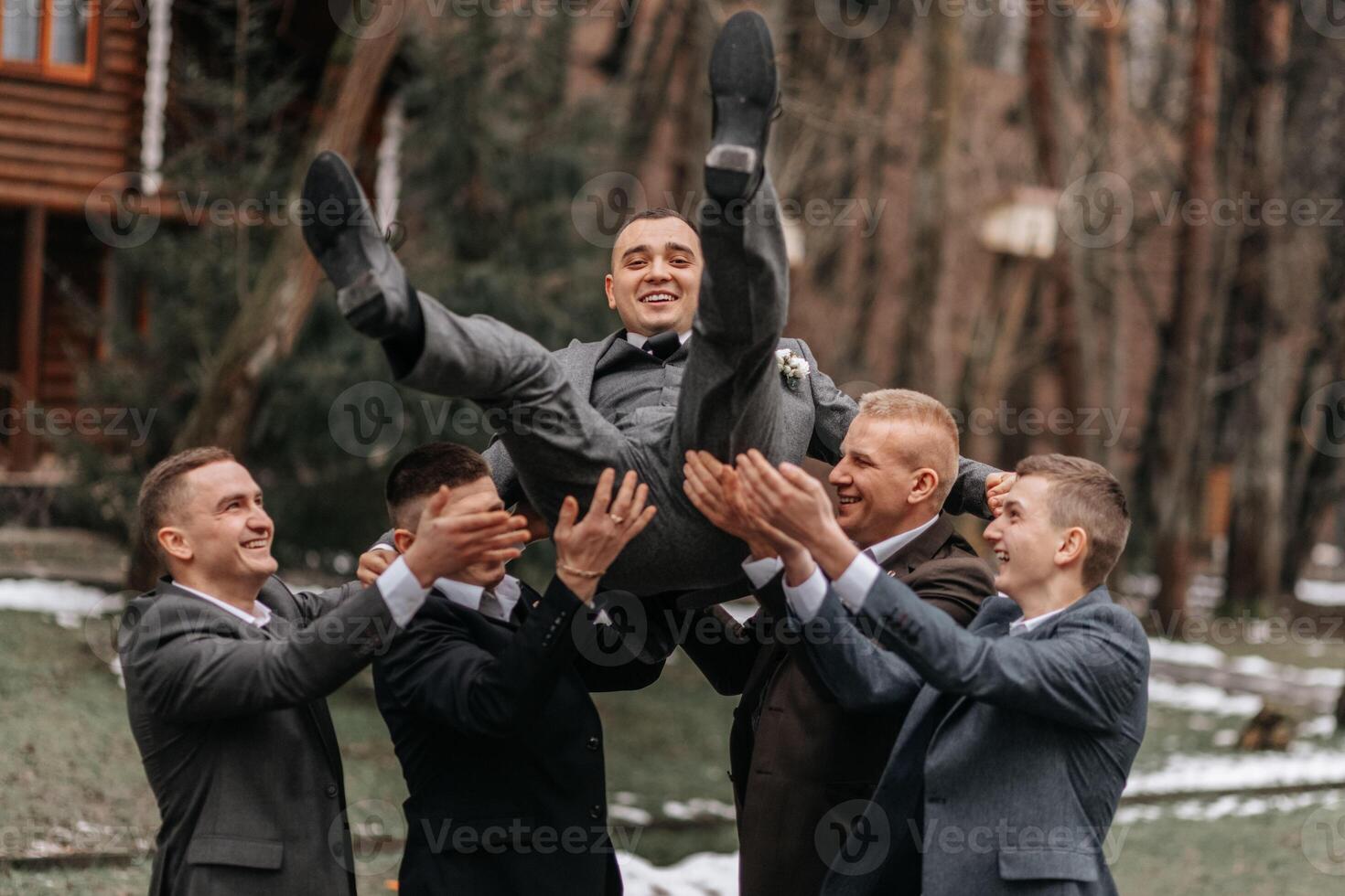 el novio y su amigos son vestido en trajes, engañando alrededor en naturaleza durante un foto disparo. un grupo de hombres. Boda en naturaleza