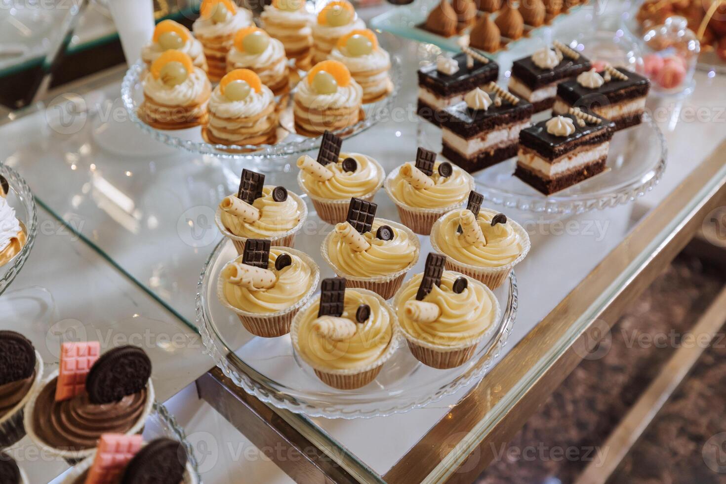 un delicioso boda. pastelitos, pasteles caramelo bar para un banquete. celebracion concepto. de moda postres mesa con dulces, dulces. frutas foto