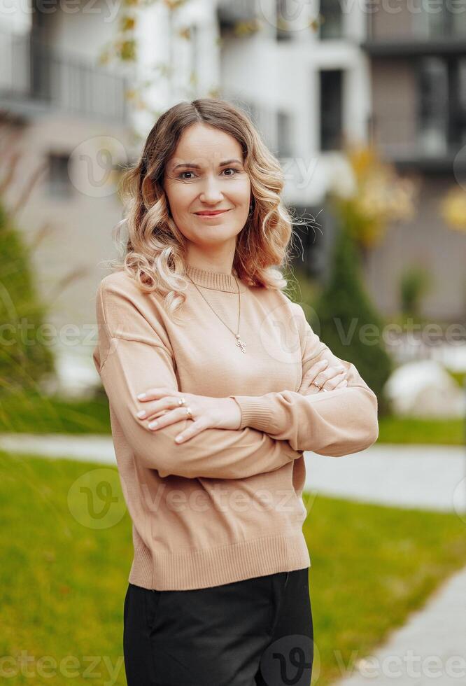 Vertical photo. Beautiful carefree young teenage girl in casual clothes. Portrait of a beautiful girl against the background of nature with a blurred background. photo