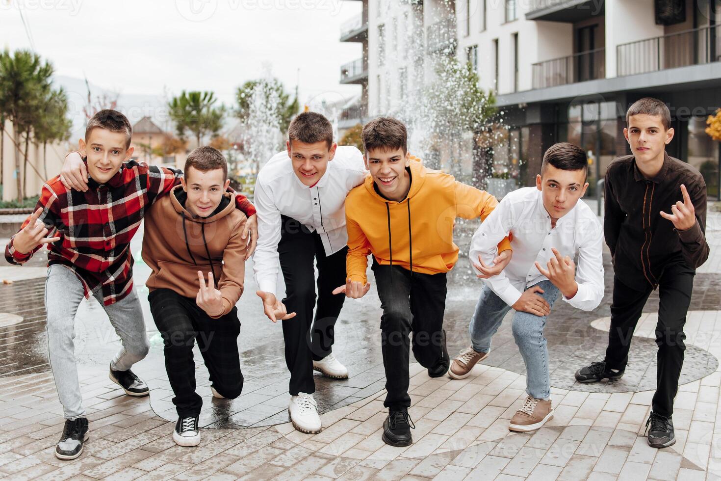 friendship, movement, action, freedom and people concept - group of happy teenagers or school friends posing and having fun outdoors on background of beautiful place or college. photo