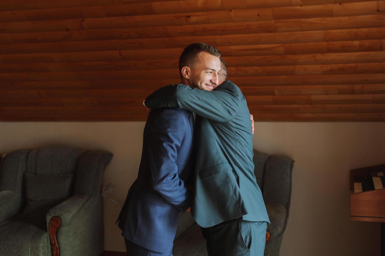 un padre abrazos su maduro hijo y ayuda él preparar para el Boda ceremonia. calentar y sincero relaciones Entre un padre y un adulto hijo. un emocional momento a un Boda foto