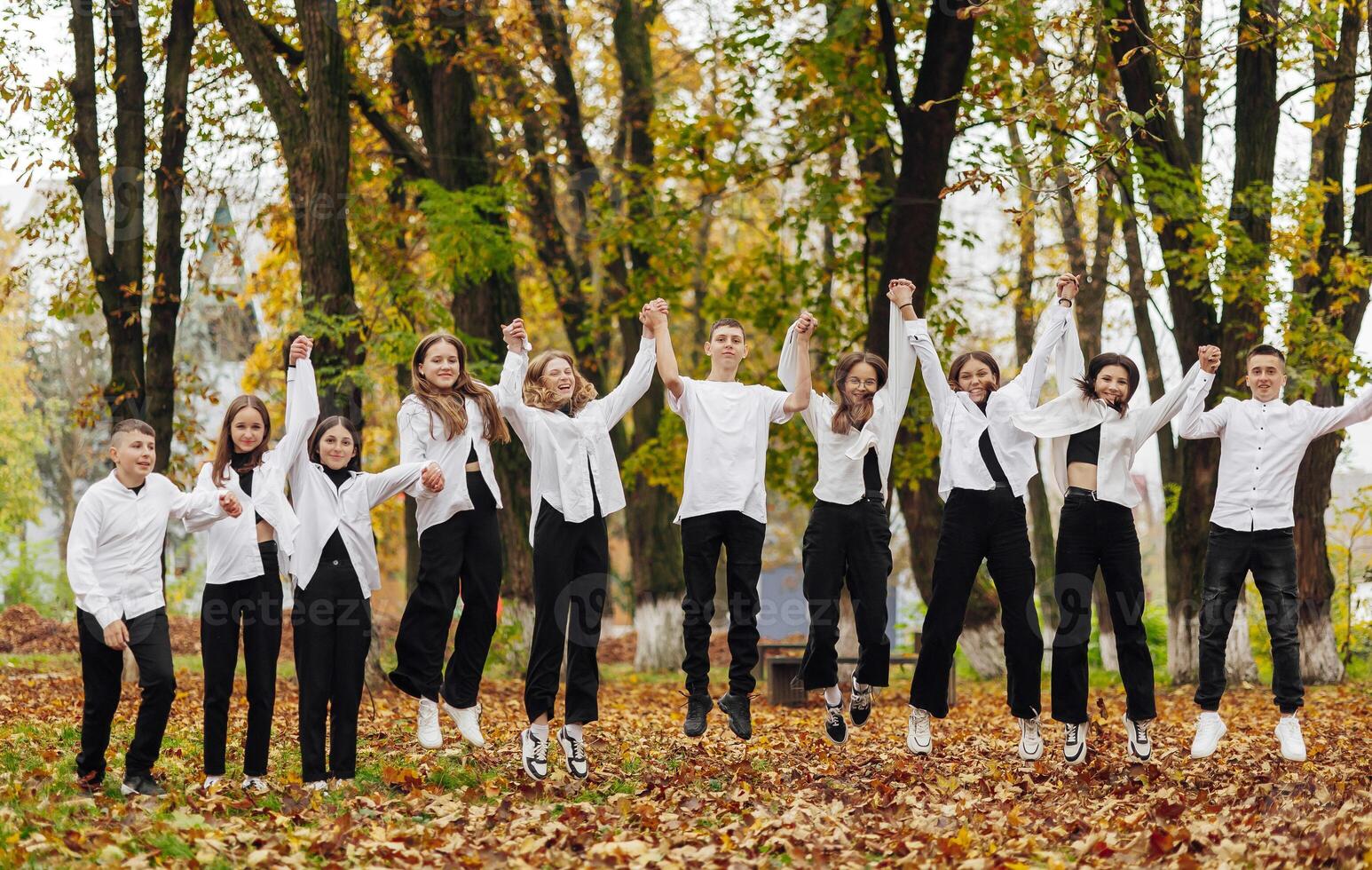 friendship, movement, action, freedom and people concept - group of happy teenagers or school friends posing and having fun outdoors against nature or forest background. photo