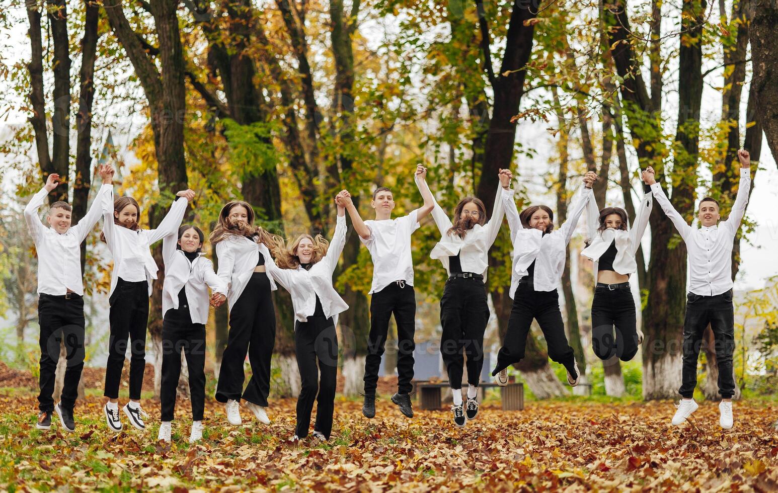 friendship, movement, action, freedom and people concept - group of happy teenagers or school friends posing and having fun outdoors against nature or forest background. photo