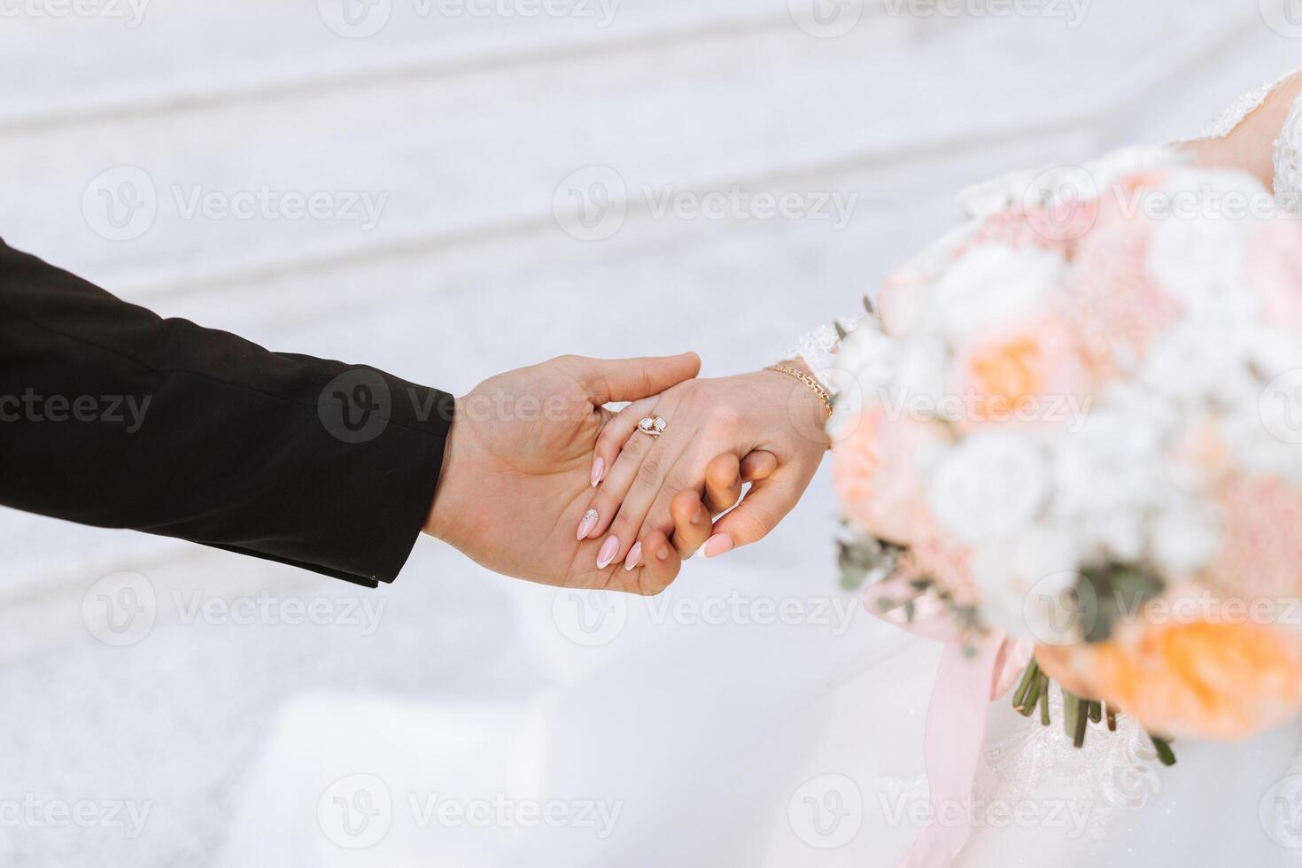 The groom tenderly holds the bride's hand after placing a wedding ring on her finger at a wedding ceremony. A beautiful wedding in the cold season. photo