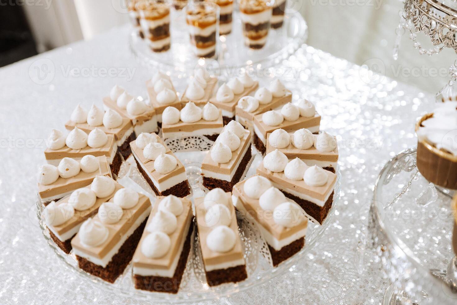 Candy bar for a wedding. Candy bar standing festive table with desserts, cupcakes and macarons. Beautiful and tasty. photo