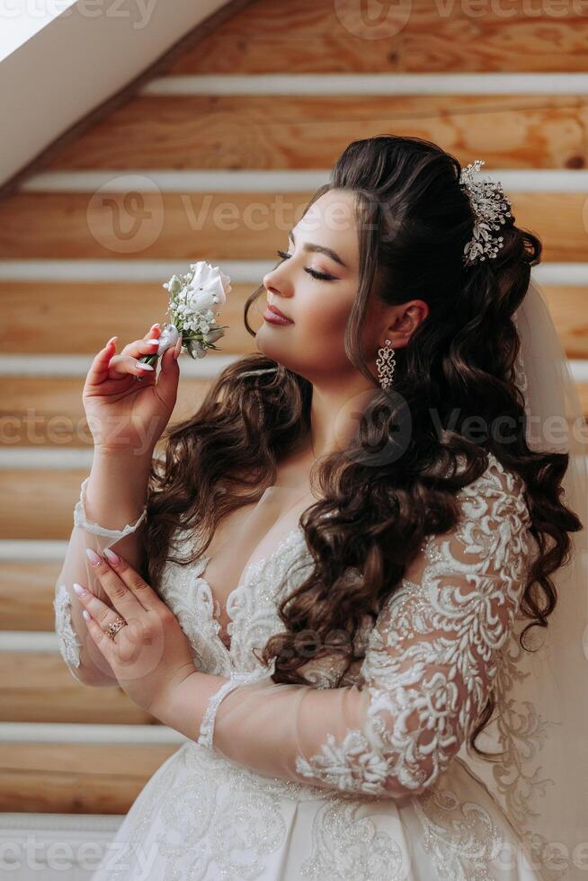 A wonderful beautiful portrait of a young bride. Beautiful bride with wedding makeup and jewelry wreath on long curly hair. Wedding photo model with brown eyes in a beautiful interior.