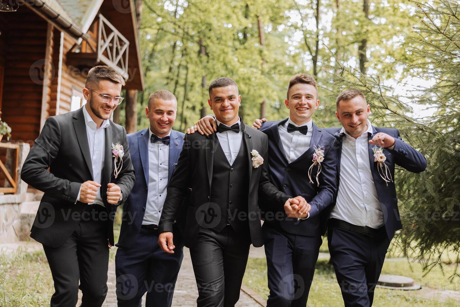 Cheerful, young, energetic witnesses of the groom next to the groom. Friends congratulate the groom. Groom and his funny friends having fun on the wedding day of the newlyweds. photo