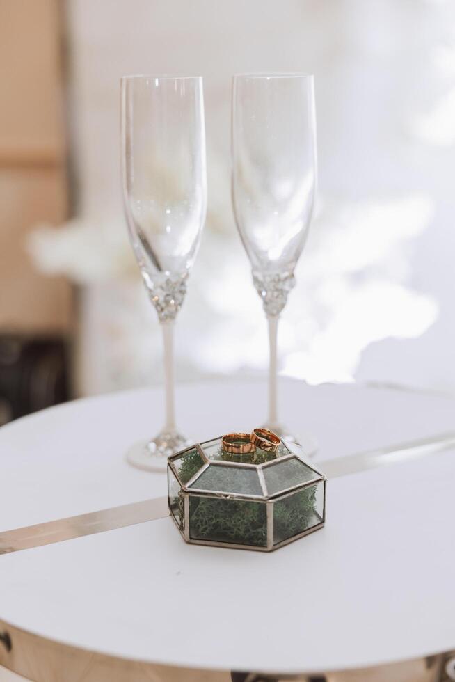 oro Boda anillos en verde bosque musgo en un vaso caja. el concepto de evento agencias para el ceremonia de el novia y novio. foto