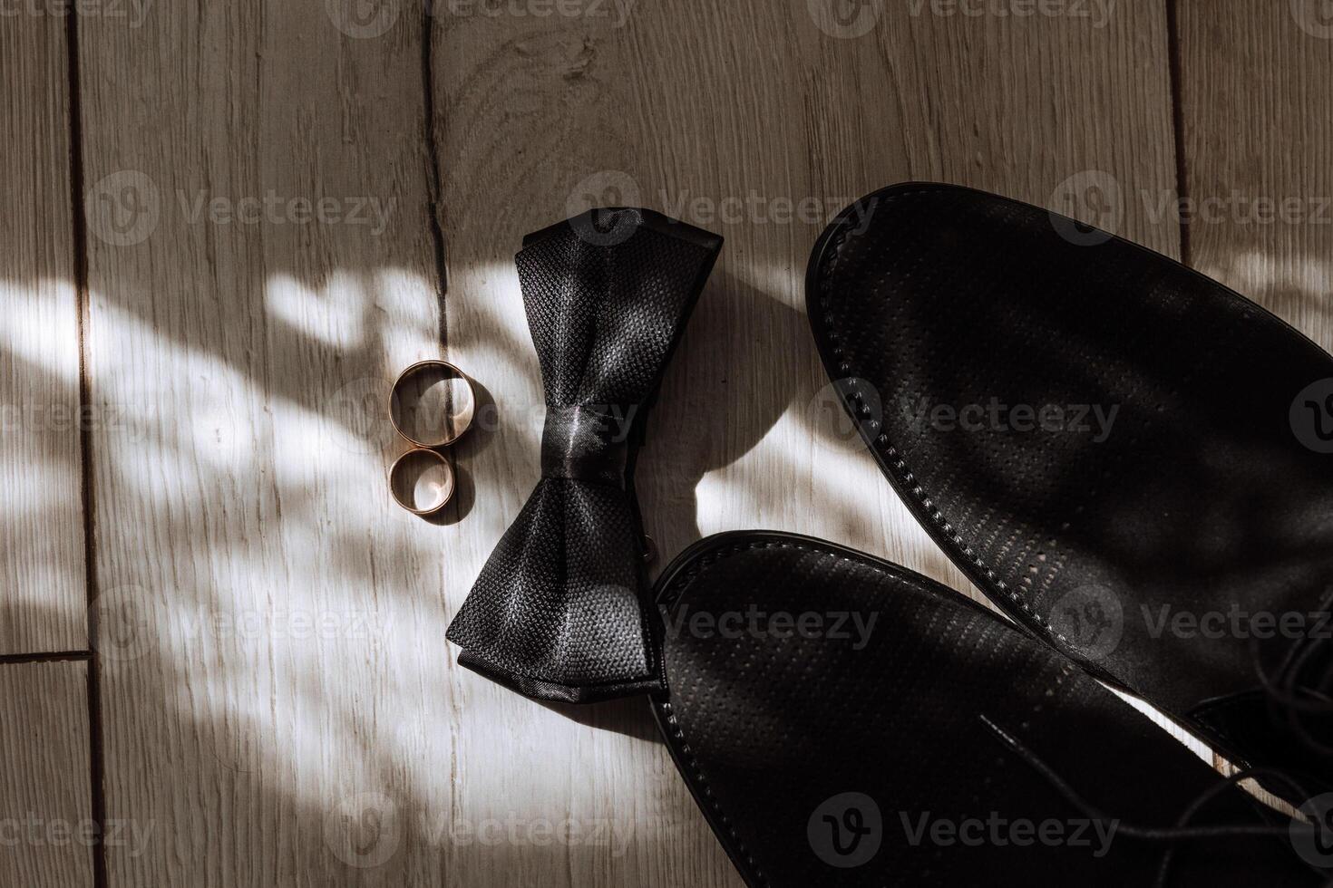 Men's accessories, groom details. Beauty is in the details. Preparation for the Wedding. Leather shoes. Gold wedding rings. Bow tie. Wedding bouquet of flowers. photo