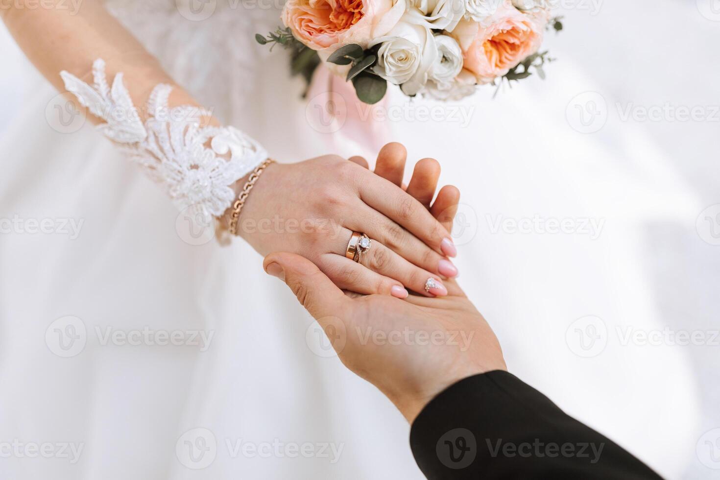 The groom tenderly holds the bride's hand after placing a wedding ring on her finger at a wedding ceremony. A beautiful wedding in the cold season. photo