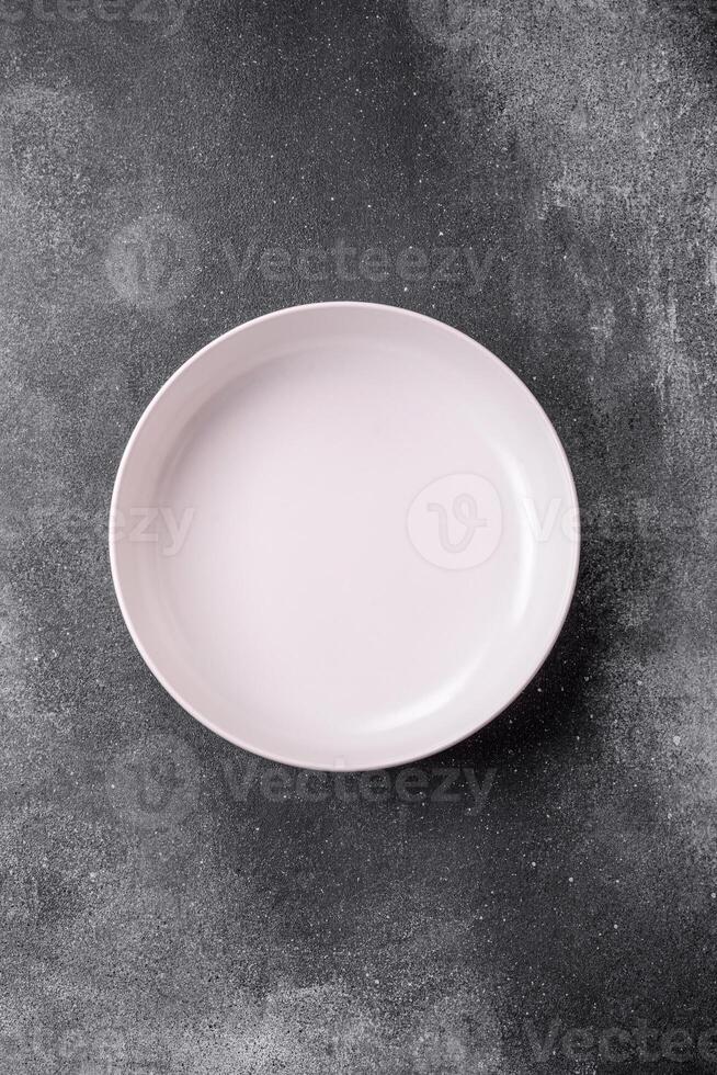 Empty round ceramic plate on a light texture background photo