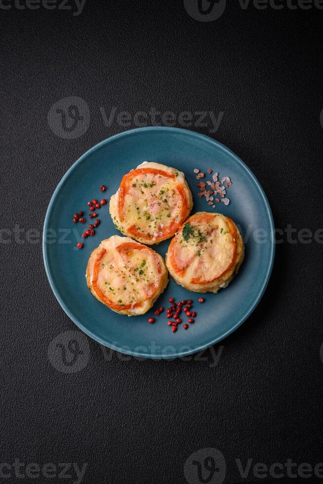 Delicious baked fish fillet with cheese, tomatoes, salt, spices and herbs photo