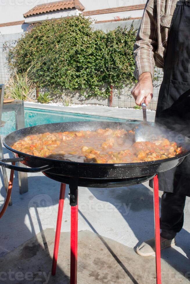 Preparing paella in the backyard photo