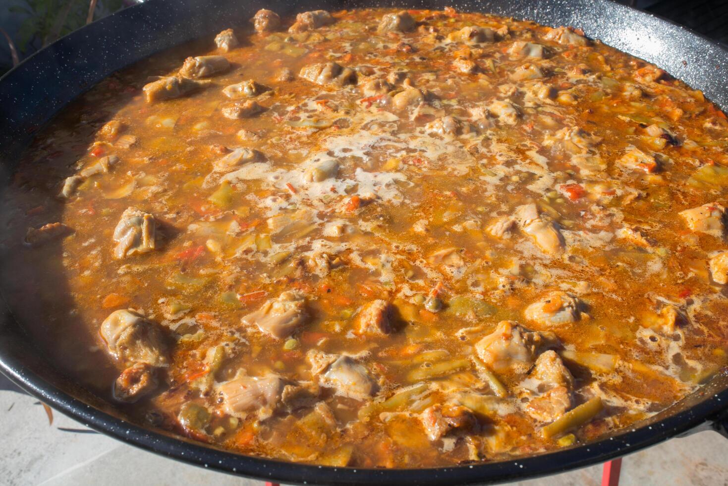 Directly above, preparing paella with meat outdoors. photo