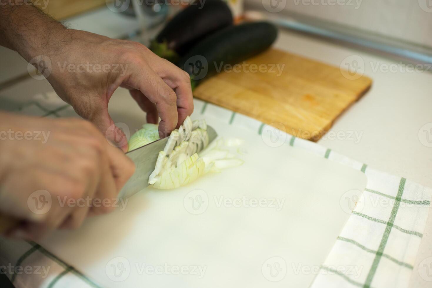 Caucasian man cutting onion into pieces photo