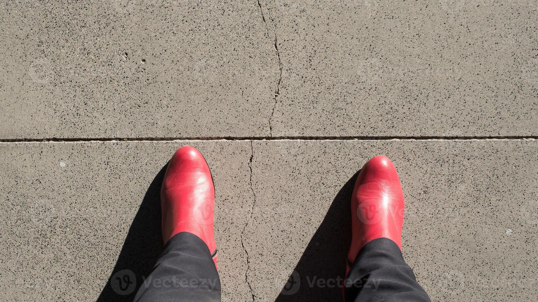 rojo botas, visto desde arriba, acerca de a cruzar un línea foto