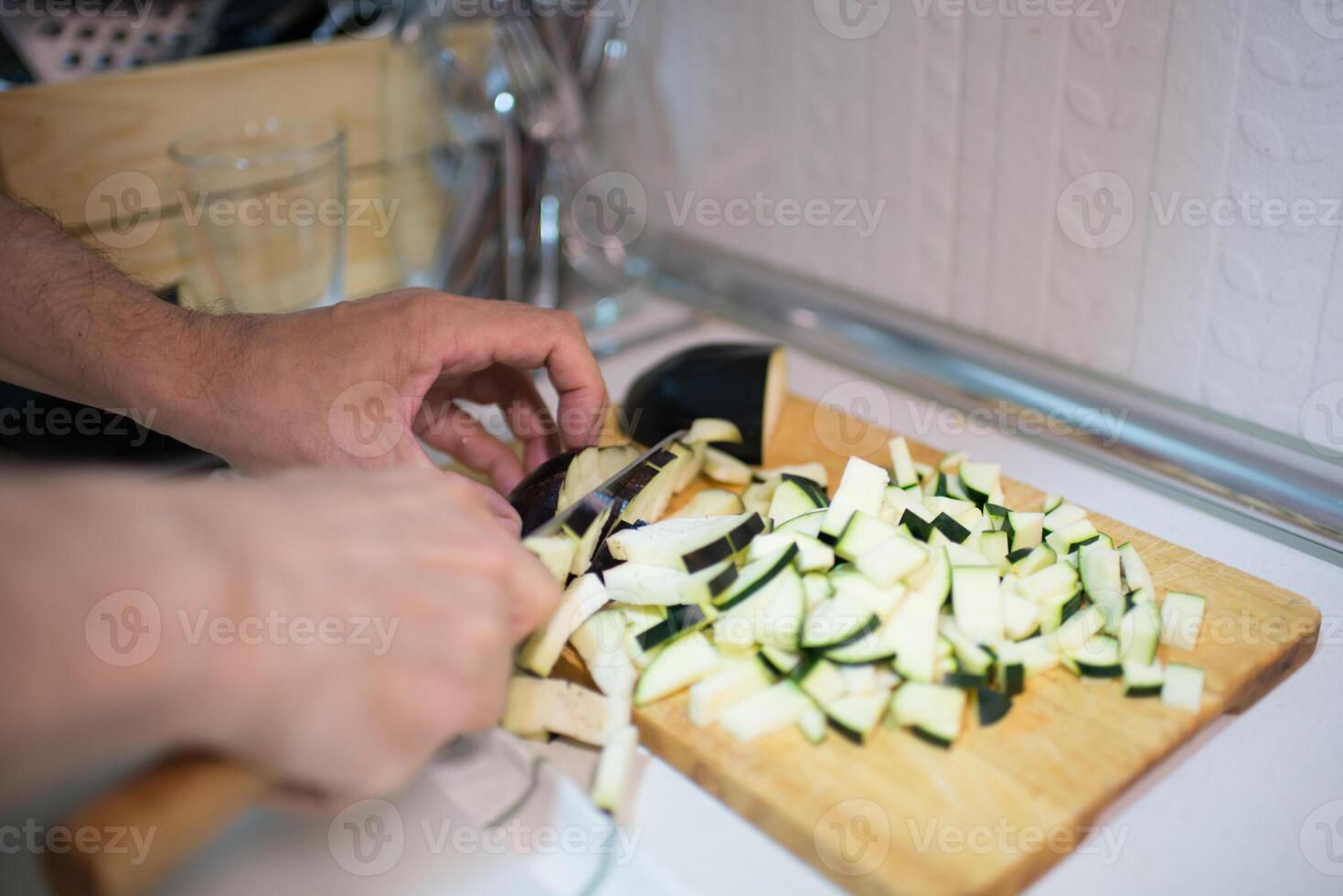 Human hands cutting zucchini into pieces. photo