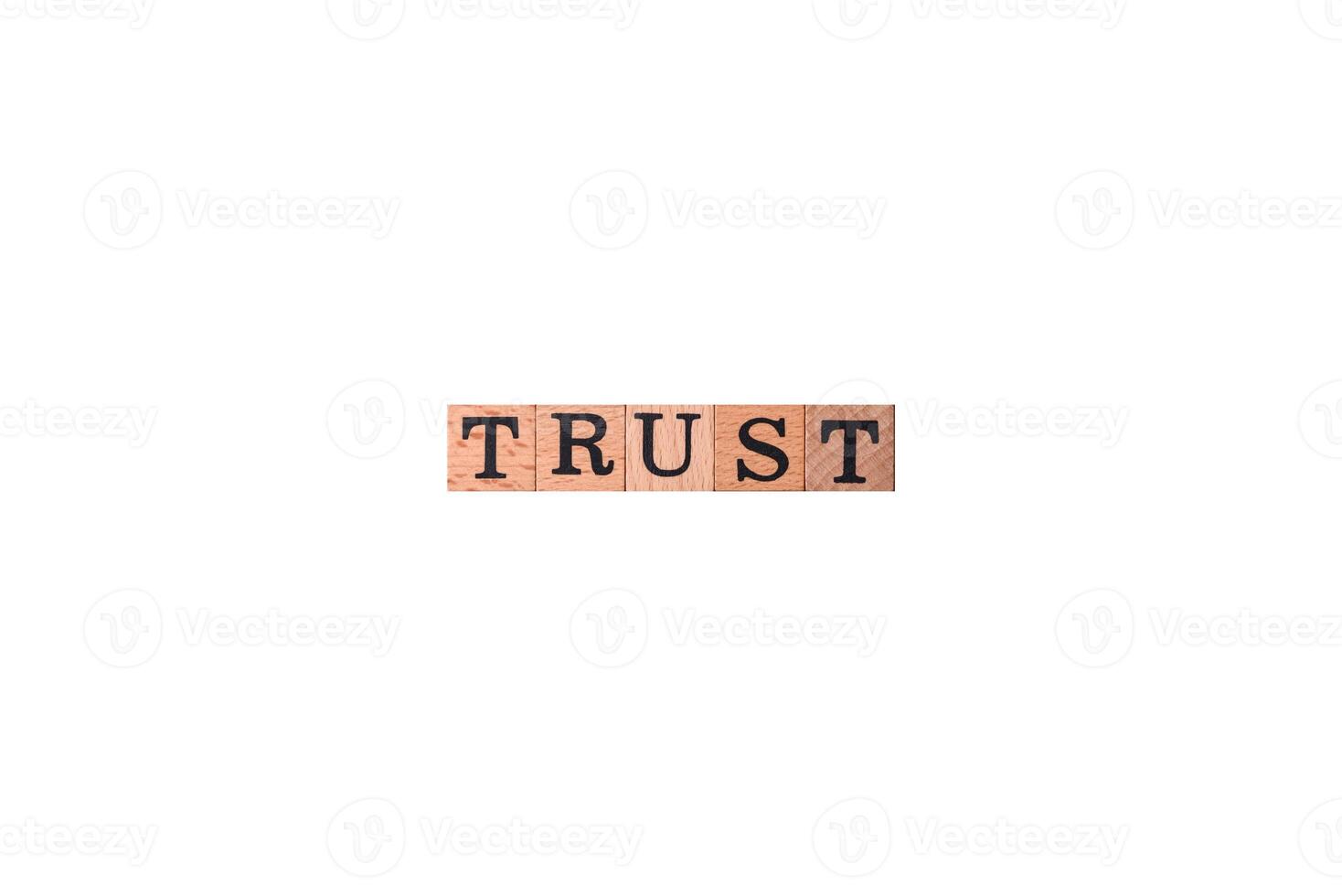 The inscription Trust made of wooden cubes on a plain background photo