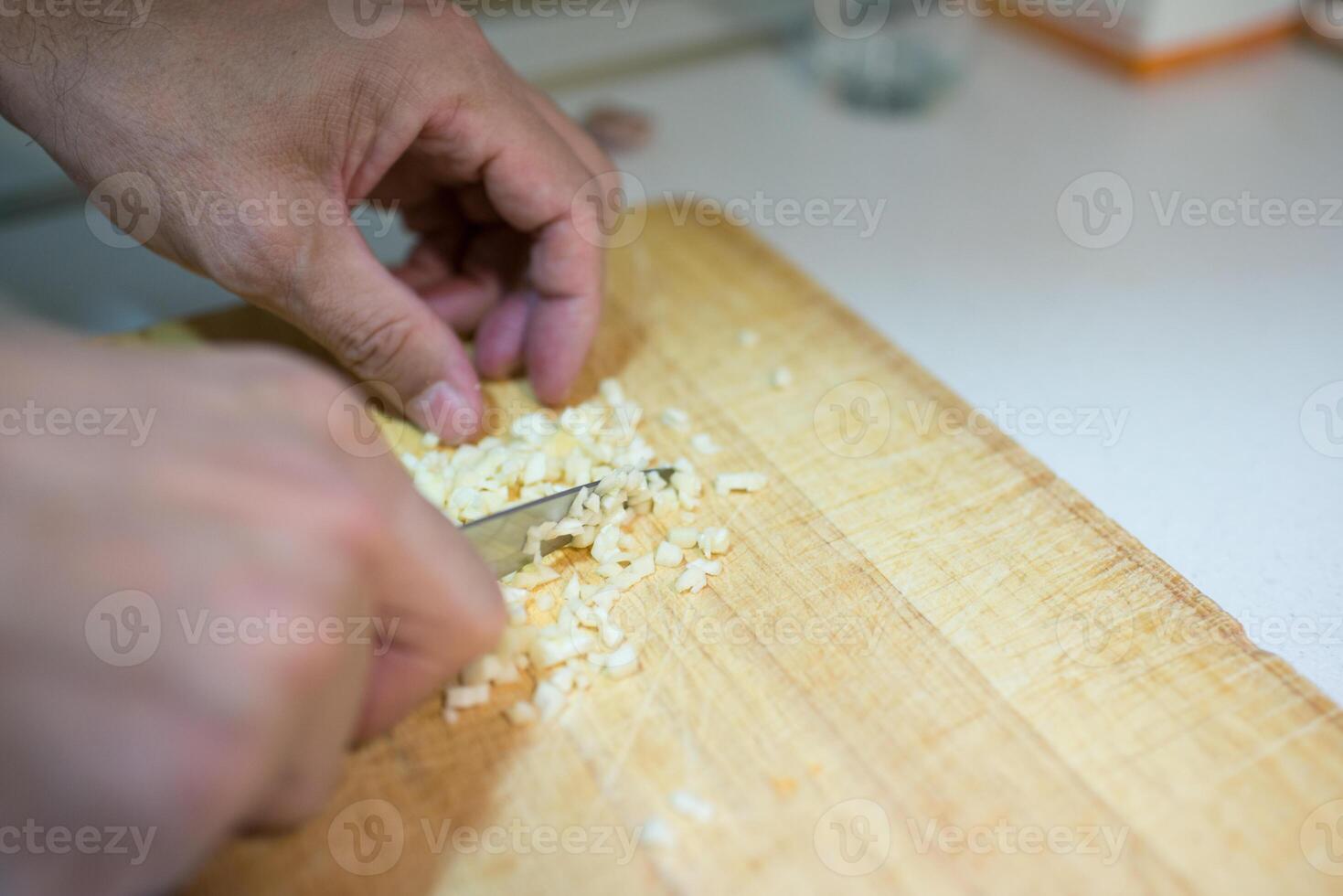 Close up of unrecognizable person cutting garlic photo