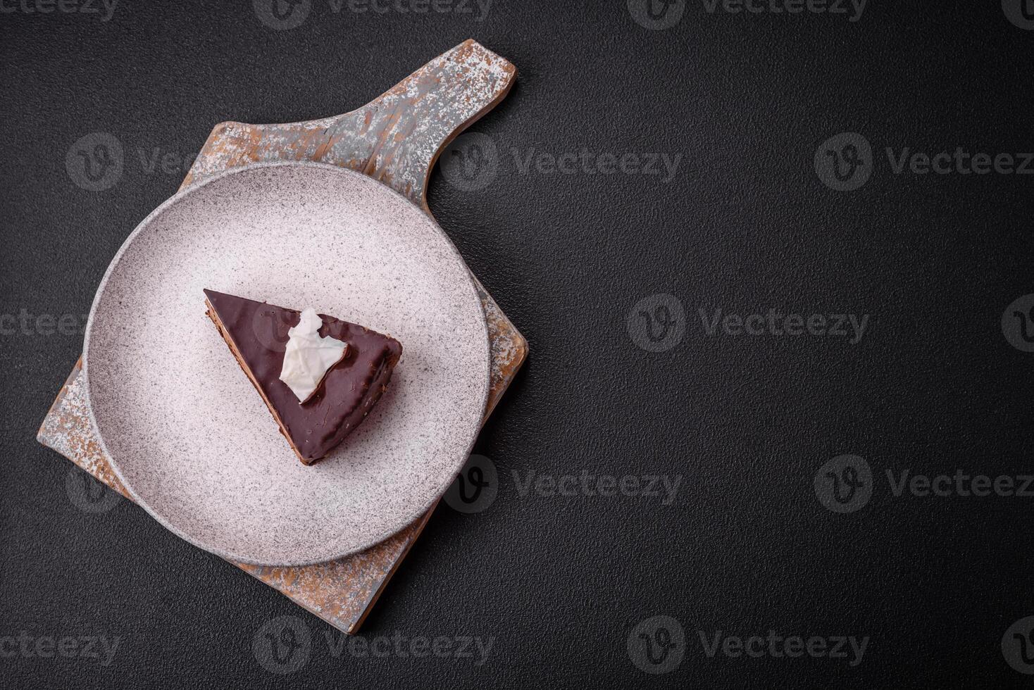 Piece of delicious sweet chocolate cake with sponge cake and cream photo
