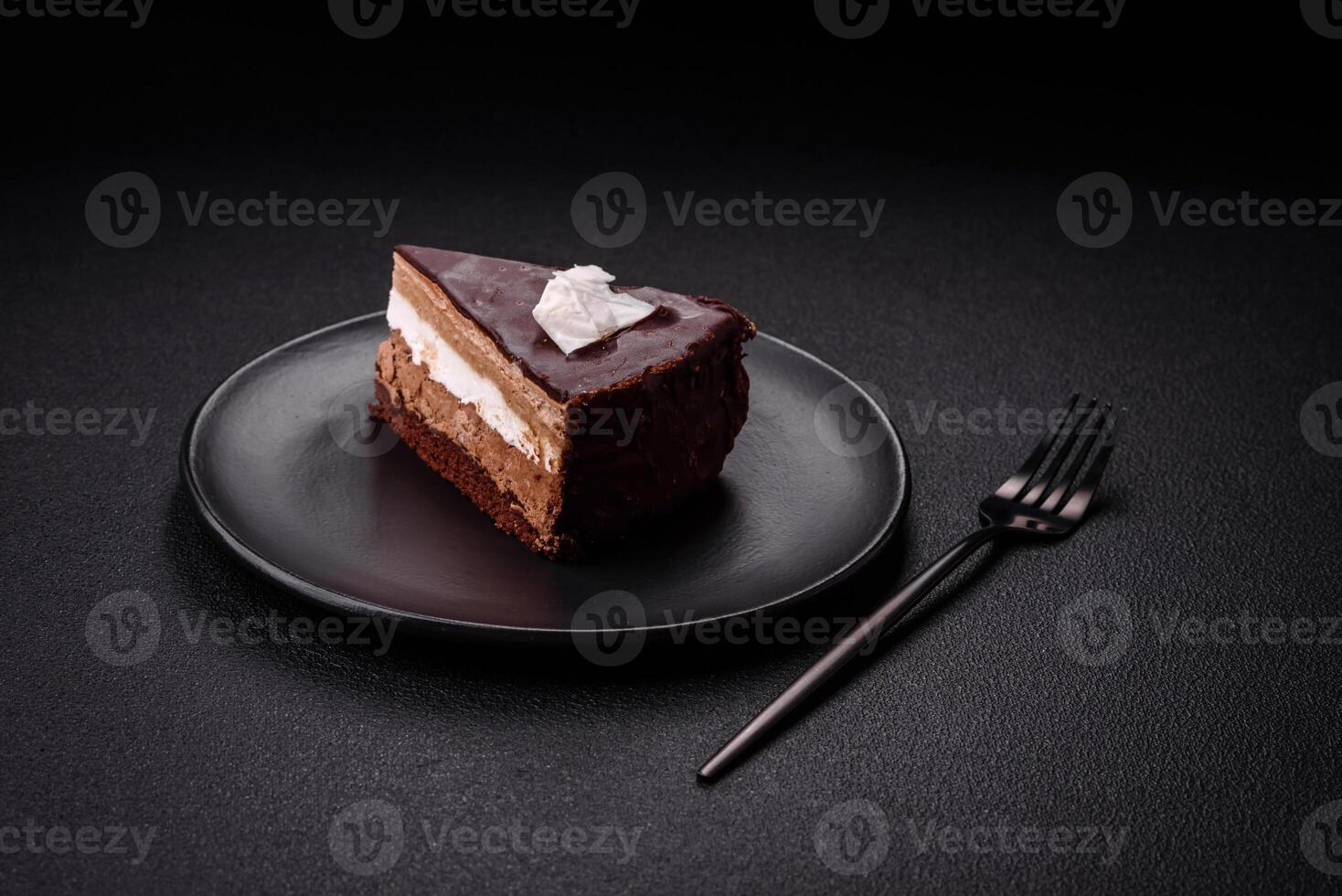 Piece of delicious sweet chocolate cake with sponge cake and cream photo