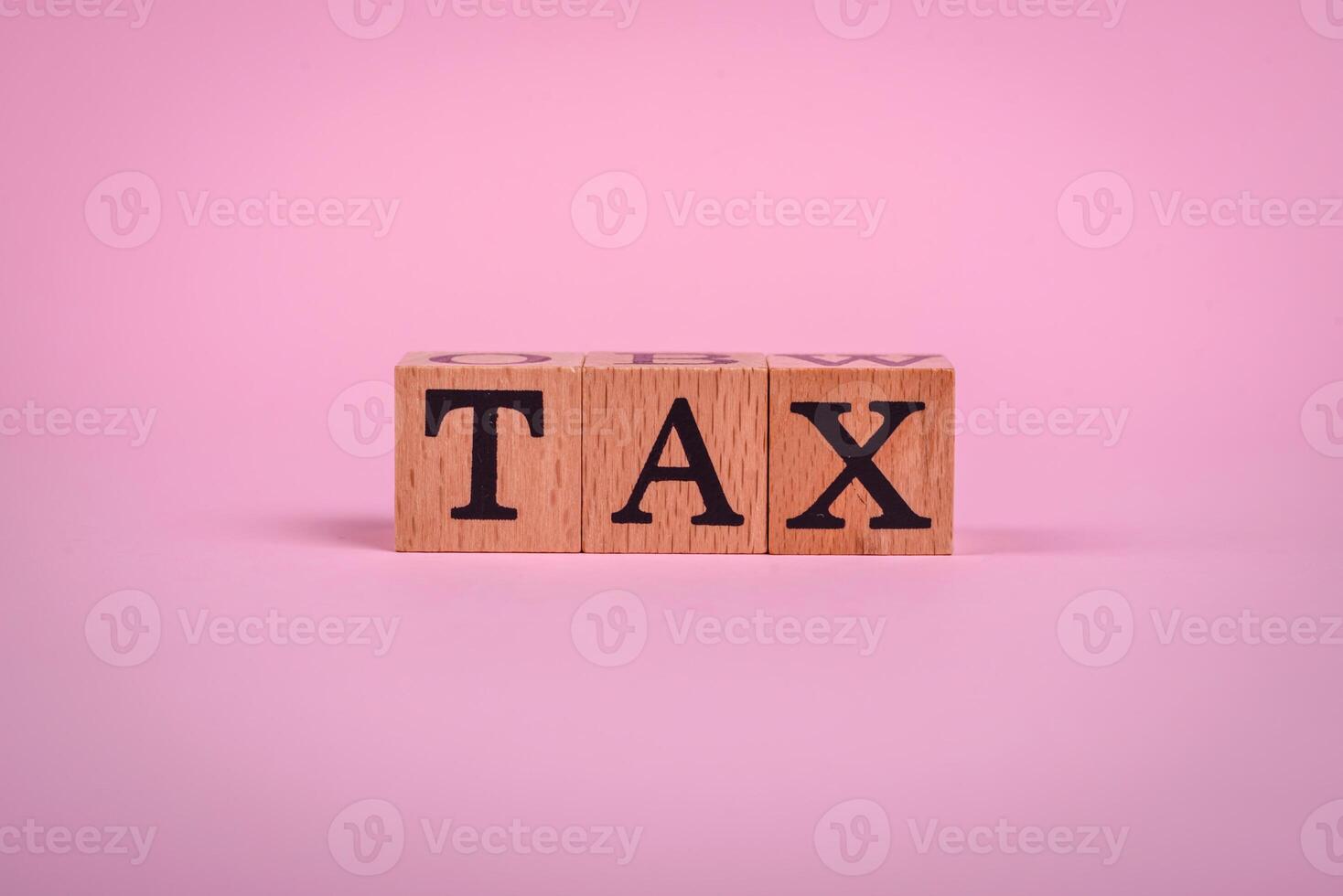 The inscription Tax made of wooden cubes on a plain background photo